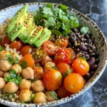 Colorful quinoa bowl with a mix of chickpeas, black beans, and cilantro.