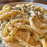 Side view of Espaguete ao Molho de Limão Siciliano showcasing creamy sauce and pasta.