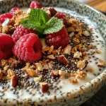 Iogurte grego com sementes de chia, granola e morangos, em foco.