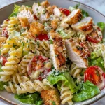 Close-up of a creamy Chicken Caesar pasta salad with colorful ingredients.