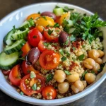 Tigela de quinoa mediterrânea com legumes frescos e grãos.