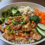 Close-up de um prato de Bowls de Frango Pegajoso Saudáveis com arroz integral, brócolis e cenouras.