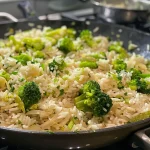 Close-up de um prato de arroz com brócolis e cenoura.