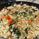 Close-up of creamy spinach rice in a bowl, garnished with parsley.