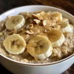 Close-up of a bowl of peanut butter banana oatmeal topped with sliced bananas.