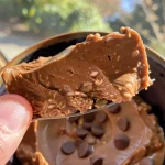 Close-up de um mingau de aveia com chocolate e manteiga de amendoim, com pedacinhos de chocolate.