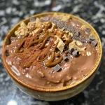 Aveia de chocolate com manteiga de amendoim em um recipiente transparente.