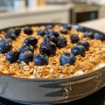 Tigela de aveia com mirtilos, cottage cheese e proteína, vista lateral.