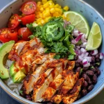 Close-up of a colorful chicken burrito bowl with sliced avocado and cherry tomatoes.