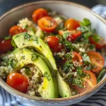 Uma tigela de quinoa com abacate, tomates-cereja e ervas frescas.