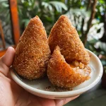Detailed shot of Coxinha Integral Assada, emphasizing its appetizing filling.