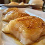 Prato de filé de peixe empanado com apresentação apetitosa.