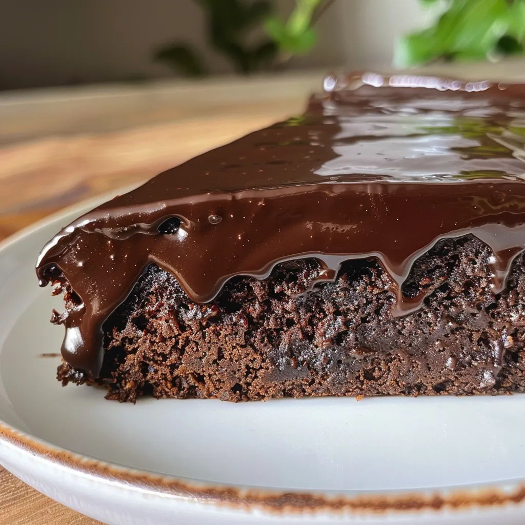 Fatia de bolo de chocolate, mostrando camadas e brilho do chocolate.