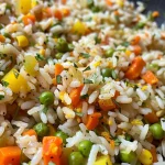 ['Arroz de legumes mistos colorido em um prato.', 'Close de arroz com vegetais variados e temperos.', 'Porção de arroz de legumes mistos com brilho e textura.', 'Mistura de arroz com vegetais congelados e especiarias.']