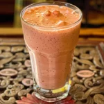 ['Copo de Lassi de Goiaba com gelo e ingredientes ao fundo.', 'Close de um Lassi de Goiaba refrescante em um copo transparente.', 'Lassi de Goiaba servido com cubos de gelo em um ambiente iluminado.', 'Bebida de Lassi de Goiaba em destaque com iogurte e goiaba ao redor.']
