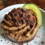 ['Mousse de chocolate com abacate em uma tigela.', 'Close-up de mousse de chocolate cremosa com abacate.', 'Taça de mousse de chocolate com abacate e textura suave.', 'Mousse de chocolate e abacate com aparência suculenta.']