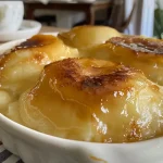 ['Pudim de abacaxi em calda com textura cremosa e caramelizada.', 'Close-up de pudim com pedaços de abacaxi e calda dourada.', 'Pudim de abacaxi em calda apresentando uma superfície brilhante.', 'Fatia de pudim de abacaxi em calda com detalhes de caramelo.']