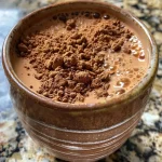 ['Pudim de chocolate rico em proteínas, cremoso e apetitoso.', 'Close-up de um pudim de chocolate com textura suave.', 'Pudim de chocolate servido em um recipiente, com aparência deliciosa.', 'Imagem de pudim de chocolate proteinado, com detalhes evidentes.']