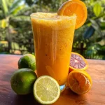 ['Suco refrescante de maracujá, laranja e gengibre em copo.', 'Close de um copo de suco de maracujá, laranja e gengibre com gelo.', 'Bebida colorida de suco de maracujá, laranja e gengibre em uma mesa.', 'Copo de suco de maracujá, laranja e gengibre decorado com hortelã.']