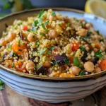 ['Salada de cuscuz marroquino colorida com vegetais e grão-de-bico.', 'Close-up de salada de cuscuz marroquino com legumes frescos.', 'Prato de salada de cuscuz marroquino com amêndoas e ervas.', 'Salada de cuscuz marroquino repleta de sabores e texturas.']