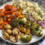 ['Vegetais coloridos cozidos na air fryer.', 'Porção de legumes assados na air fryer.', 'Close de vegetais variados preparados na air fryer.', 'Mistura de vegetais crocantes na air fryer.']