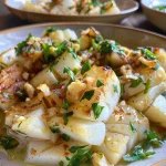 ['Close-up de um prato de bacalhau com castanhas, decorado com espinafre.', 'Porção suculenta de bacalhau ao lado de castanhas, com alho e cebola.', 'Bacalhau desfiado com castanhas e espinafre, servido em um prato colorido.', 'Prato de bacalhau com castanhas, folhas de louro e queijo ralado por cima.']