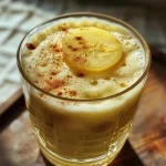 ['Copo de Chá de Pera com Gengibre em close.', 'Chá de Pera com fatia de gengibre ao lado.', 'Bebida quente de chá de pera em uma xícara.', 'Infusão de pera e gengibre em vista lateral.']