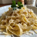 ['Prato de tagliatelle com alho, nozes e ervas.', 'Close-up de tagliatelle com molho de alho e nozes.', 'Massas italianas decoradas com nozes e ervas frescas.', 'Porção de tagliatelle com alho e nozes em um prato.']